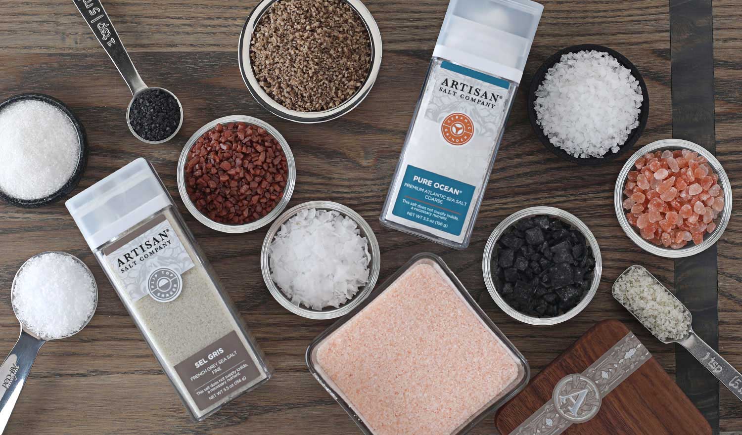 An assortment of Artisan Salt Company products in packaging and bowls