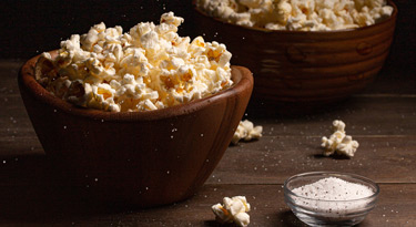 Popcorn in wooden bowls sprinkled with salt