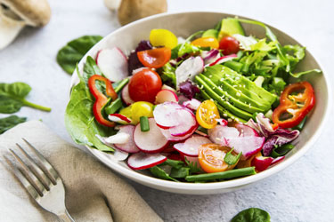 Salad with avocados, radishes, peppers and tomatoes